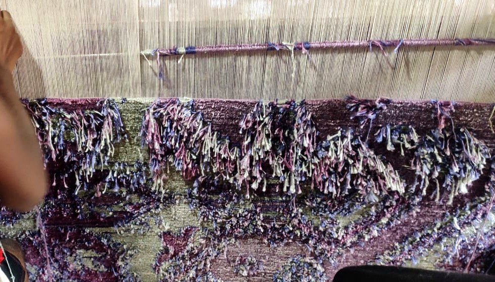 A bamboo silk rug on the loom &mdash; the sheen shifts as you move around the pile