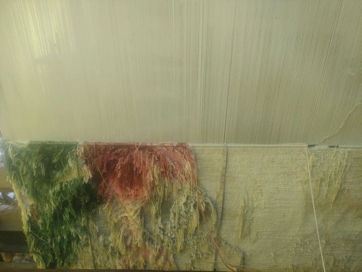 A hand-knotted silk rug in progress on the loom at PiHue, Bhadohi